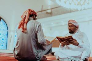 une groupe de les musulmans en train de lire le saint livre de le coran dans une moderne mosquée pendant le musulman vacances de Ramadan photo