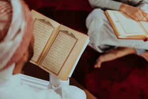 une groupe de les musulmans en train de lire le saint livre de le coran dans une moderne mosquée pendant le musulman vacances de Ramadan photo