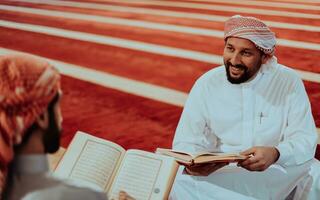 une groupe de les musulmans en train de lire le saint livre de le coran dans une moderne mosquée pendant le musulman vacances de Ramadan photo