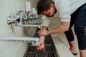 une musulman performant ablution. rituel religieux nettoyage de les musulmans avant performant prière. le processus de nettoyage le corps avant prière photo