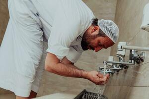 une musulman performant ablution. rituel religieux nettoyage de les musulmans avant performant prière. le processus de nettoyage le corps avant prière photo