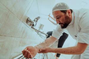 une musulman performant ablution. rituel religieux nettoyage de les musulmans avant performant prière. le processus de nettoyage le corps avant prière photo