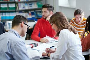 groupe d'étudiants travaillant ensemble sur un projet scolaire sur une tablette à l'université moderne photo