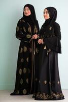 deux magnifique musulman femme dans à la mode robe avec hijab isolé sur moderne cyan Contexte représentant concept de moderne Islam et Ramadan kareem photo