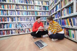 les élèves utilisent un cahier, un ordinateur portable et une bibliothèque scolaire photo