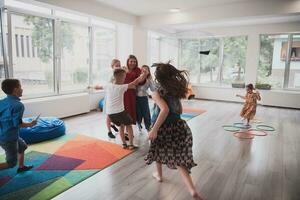 une enfant étreindre une prof dans une moderne Jardin d'enfants photo