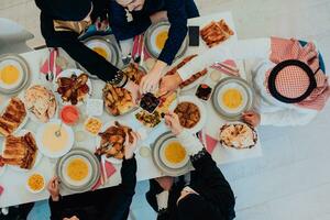 musulman famille ayant iftar dîner en buvant l'eau à Pause festin. en mangeant traditionnel nourriture pendant Ramadan festoyer mois à maison. le islamique halal en mangeant et en buvant dans moderne Accueil photo