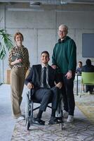 une homme d'affaire avec invalidité dans une fauteuil roulant est entouré par favorable collègues dans une moderne bureau, mettant en valeur le force de travail en équipe, inclusivité, et responsabilisation dans le visage de défis. photo
