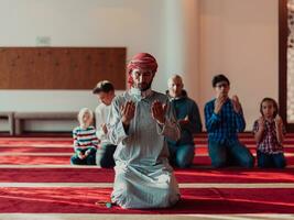 une groupe de les musulmans dans une moderne mosquée prier le musulman prière namaz, pendant le saint mois de Ramadan photo