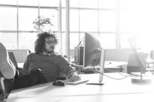 homme d'affaires assis avec les jambes sur le bureau photo