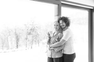 jeune couple appréciant le café du matin près de la fenêtre photo