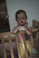 mignon petit bébé d'un an et faisant ses premiers pas au lit photo