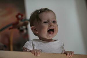 mignon petit bébé d'un an et faisant ses premiers pas au lit photo