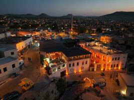 aérien vue de Naturel Roche formations dans le coucher de soleil, vallée avec la grotte Maisons dans cappadoce, Turquie. Naturel paysage ville lumières à le nuit. photo