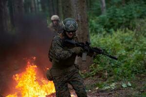 soldat en action la nuit sautant par-dessus le feu photo