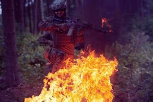 soldat en action la nuit sautant par-dessus le feu photo