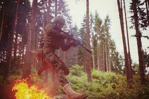 soldat en action la nuit sautant par-dessus le feu photo