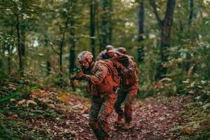 une groupe de moderne guerre soldats est combat une guerre dans dangereux éloigné forêt domaines. une groupe de soldats est combat sur le ennemi ligne avec moderne armes. le concept de guerre et militaire conflits photo