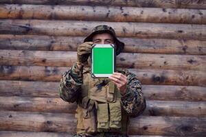 soldat à l'aide d'un ordinateur tablette dans un camp militaire photo