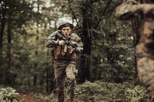 une groupe de moderne guerre soldats est combat une guerre dans dangereux éloigné forêt domaines. une groupe de soldats est combat sur le ennemi ligne avec moderne armes. le concept de guerre et militaire conflits photo