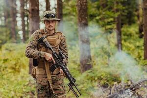 une moderne guerre soldat sur guerre devoir dans dense et dangereux forêt domaines. dangereux militaire porter secours opérations photo