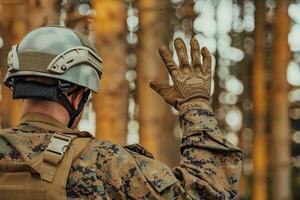 moderne guerre soldat officier est montrant tactique main signaux à silencieusement donner ordres et alertes pour équipe équipe forêt environnement photo