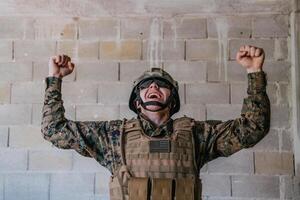 Succès dans le guerre campagne. une soldat avec élevé mains fête le réussi conquête de ennemi territoire photo