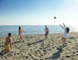 un groupe de jeunes s'amuse et joue au beach-volley photo