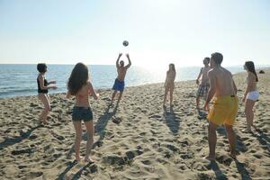 un groupe de jeunes s'amuse et joue au beach-volley photo