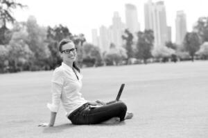femme avec ordinateur portable dans le parc photo