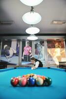 jeune homme joue au jeu de billard pro photo