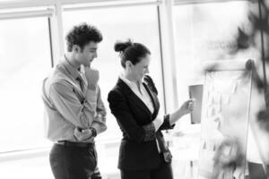 Jeune couple travail ensemble et prise Remarques sur retourner planche à Bureau photo