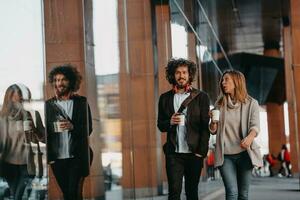 homme d'affaires et femme d'affaires parlant et tenant des bagages voyageant en voyage d'affaires, transportant du café frais dans leurs mains. concept d'entreprise photo