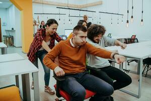 équipe bâtiment et Bureau amusement. Jeune de bonne humeur hommes d'affaires dans intelligent décontractée porter ayant amusement tandis que courses sur Bureau chaises et souriant. photo