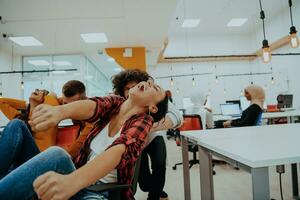 équipe bâtiment et Bureau amusement. Jeune de bonne humeur hommes d'affaires dans intelligent décontractée porter ayant amusement tandis que courses sur Bureau chaises et souriant. photo