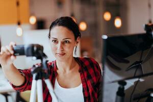 une Jeune femme en utilisant une caméra à présent sa affaires avec en ligne clients photo