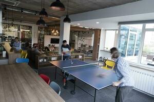 jouer au tennis de ping-pong dans un espace de bureau créatif photo