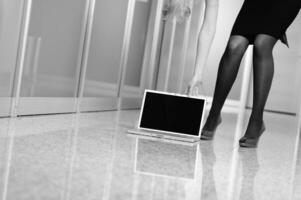 femme d'affaires debout avec une chaussure sur un ordinateur portable photo