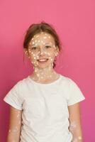 portrait de une peu école fille avec varicelle, antiseptique crème appliqué à visage et corps .coloré Contexte. photo