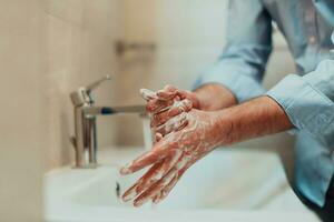 homme en utilisant savon et la lessive mains en dessous de le l'eau robinet. hygiène concept main fermer détail. photo