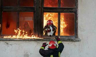 sapeur pompier héros porter bébé fille en dehors de brûlant bâtiment zone de Feu incident. porter secours gens de dangereux endroit photo