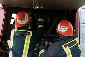 groupe de Feu combattants permanent sur de soi après une bien terminé porter secours opération. pompiers prêt pour urgence service. photo