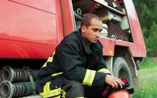 déprimé et fatigué sapeur pompier près Feu camion. photo