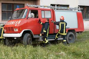 groupe de Feu combattants permanent sur de soi après une bien terminé porter secours opération. pompiers prêt pour urgence service. photo