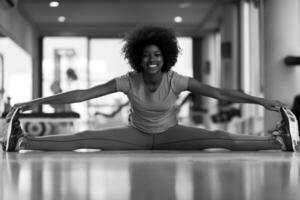 femme dans une salle de sport qui s'étire et s'échauffe avant l'entraînement photo