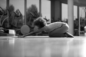 femme afro-américaine faisant du yoga dans la salle de sport photo