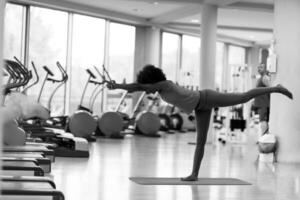 femme afro-américaine faisant du yoga dans la salle de sport photo