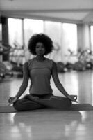 femme afro-américaine faisant du yoga dans la salle de sport photo