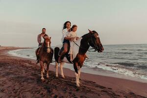 la famille passe du temps avec ses enfants tout en faisant de l'équitation ensemble sur une plage de sable. mise au point sélective photo