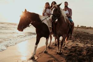 la famille passe du temps avec ses enfants tout en faisant de l'équitation ensemble sur une plage de sable. mise au point sélective photo